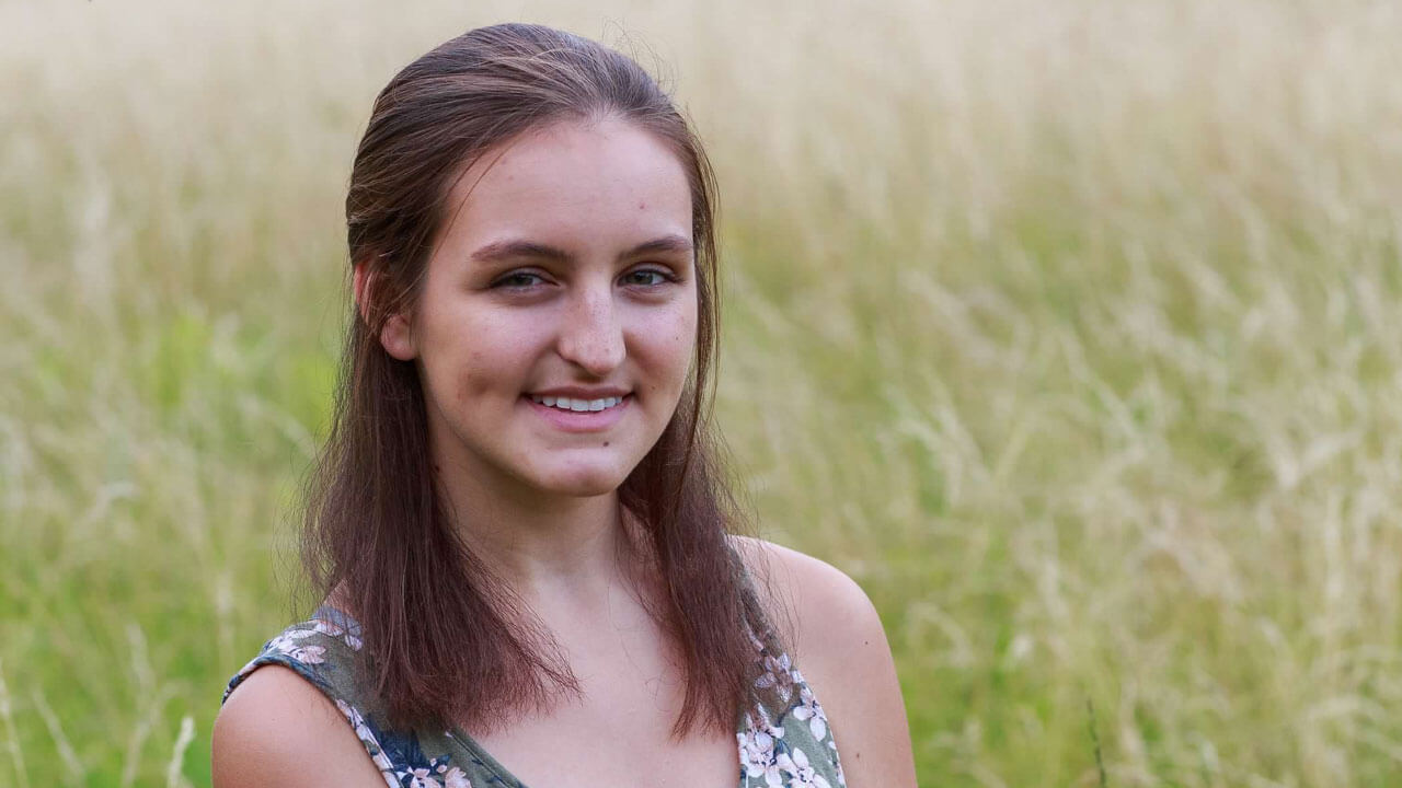 Jessica Serna smiles in a grassy field