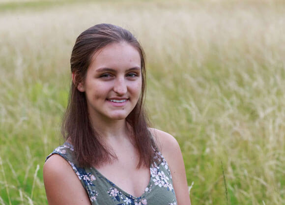 Jessica Serna smiles in a grassy field