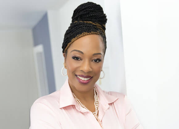 Nadine Barnett Cosby smiles for a headshot wearing a pink shirt.