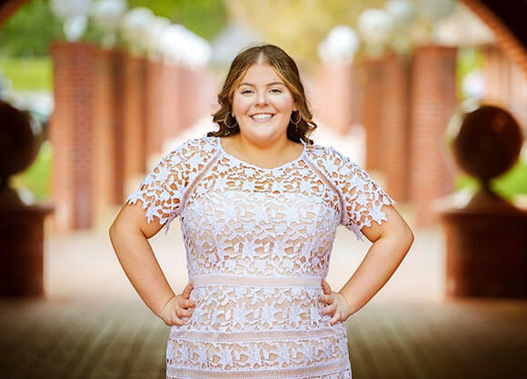 Rachel Aaron in a white dress smiling