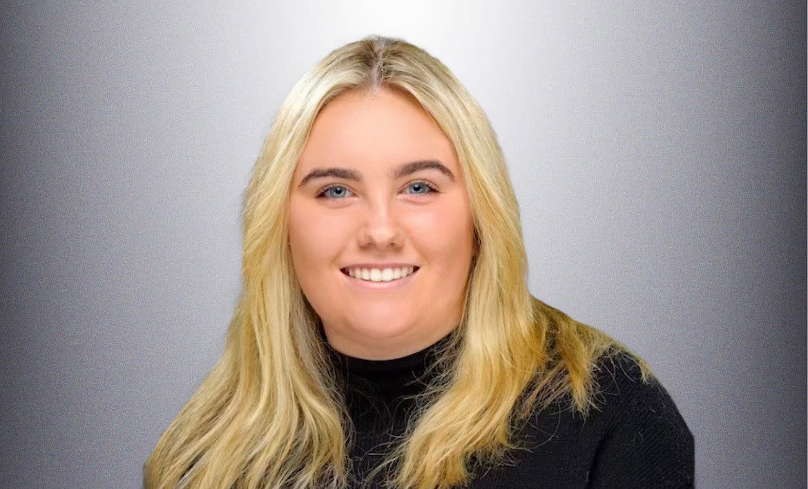 Woman with blonde hair, blue eyes, and wearing a black shirt for her portrait