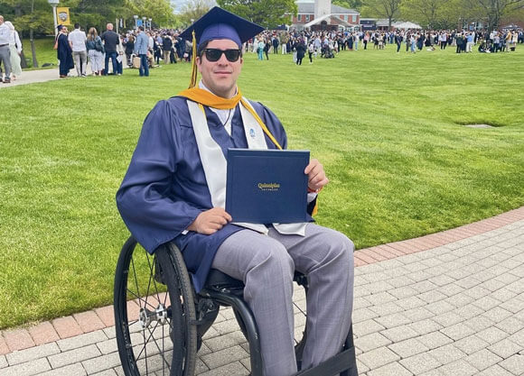 Claudio Cabrera holding up his diploma