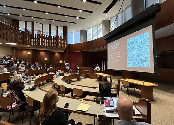 An audience watches speaker at the School of Law conference