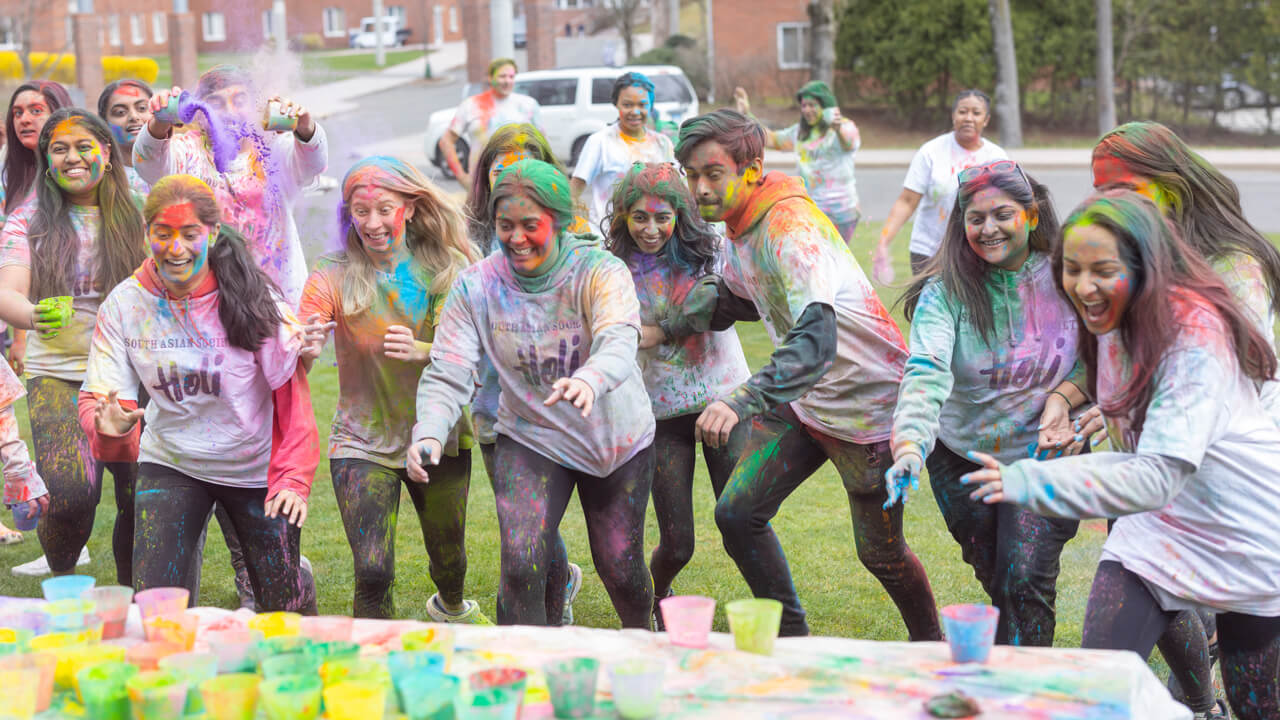 Students celebrating Holi, the Festival of Color with the tradition of throwing colored powder at one another.