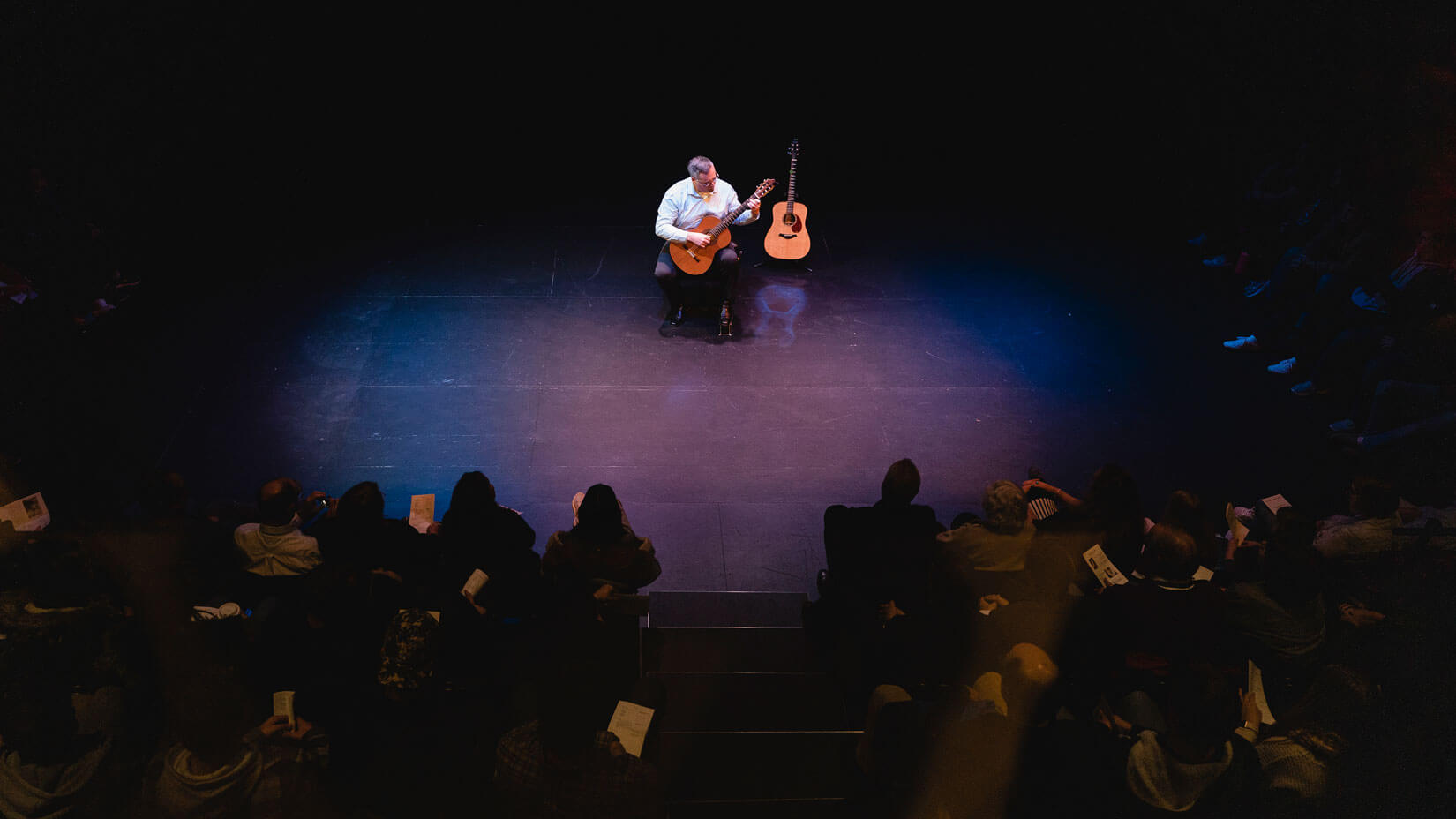 George Sprengelmeyer playing the guitar in the black box theater.