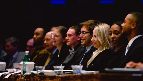 A panel of students looking to the front of the room