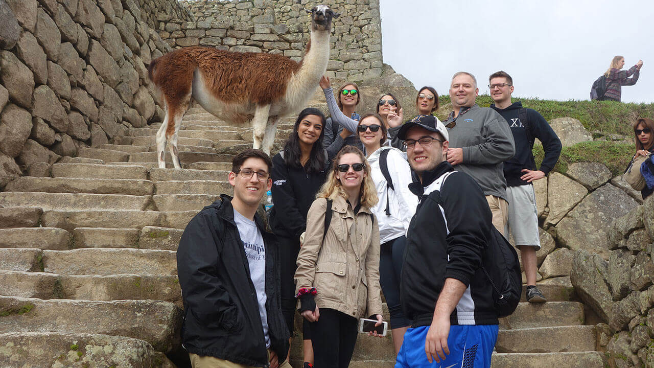 A group of students stands on the steps of ancient Peru