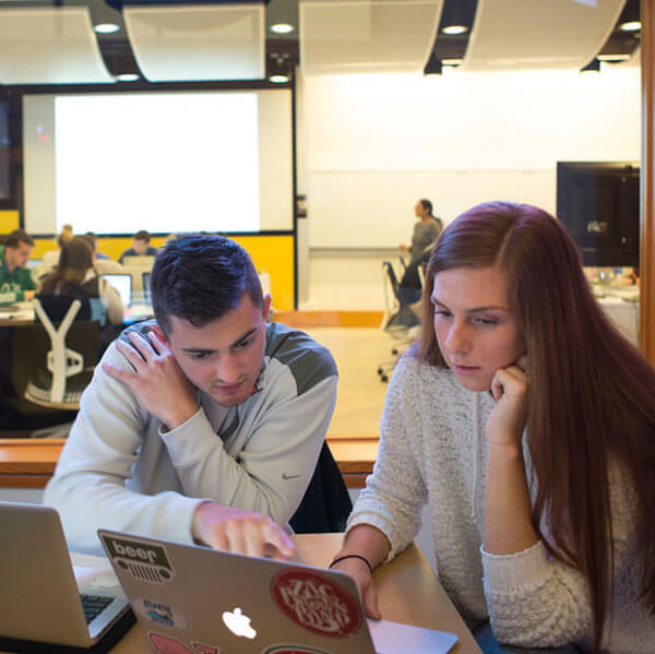 Students work on their laptops in the study room outside the Financial Technology Center.