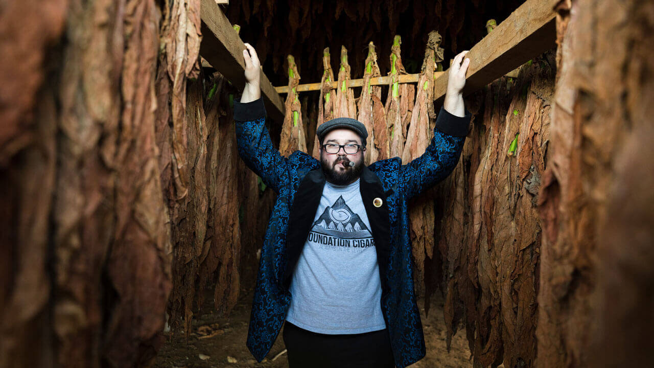 Nicholas Melillo, Cigar aficionado and Quinnipiac Alumn, in and around one of his tobacco barns