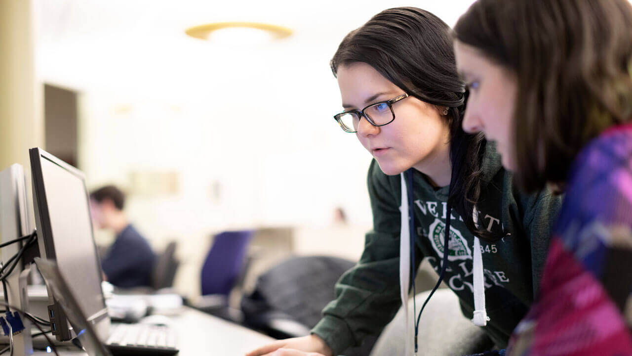 Two students looking at a laptop