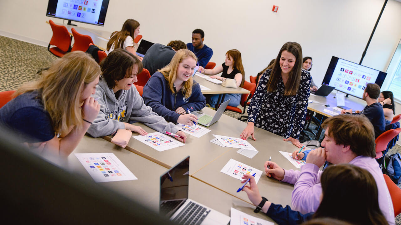 Students discuss and observe various advertising campaigns with a professor in the School of Communications