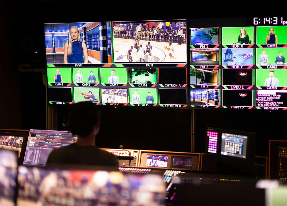 Journalism students monitor the screens in the control room of the communications center during a live broadcast