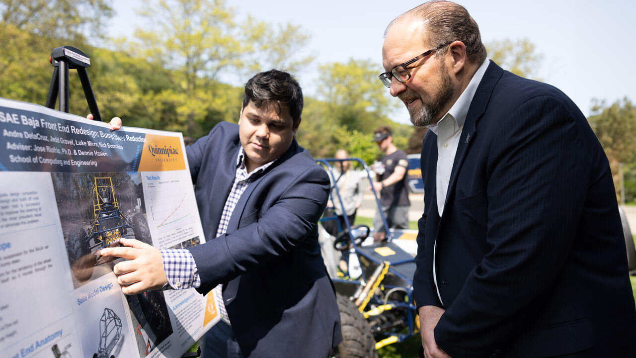 A student presents their project to a professor.