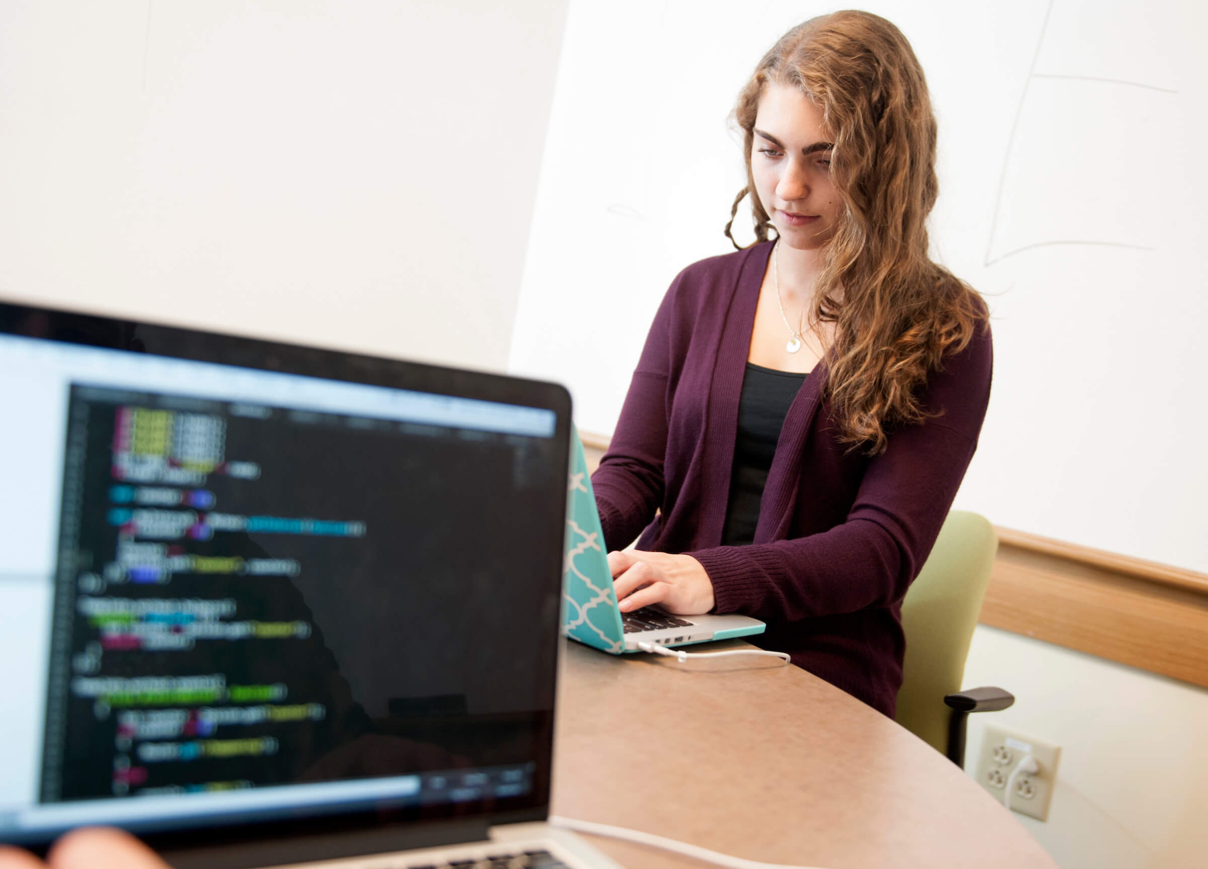 Student sits at table working on her laptop