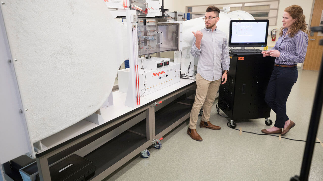 Students display the School of Engineering's areodynamics simulation chamber