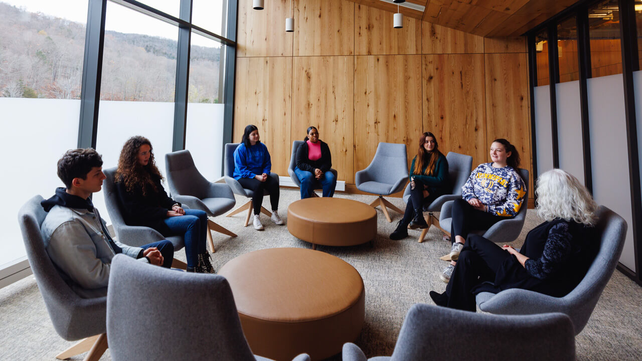 A group of young adults sitting in a circle of chairs