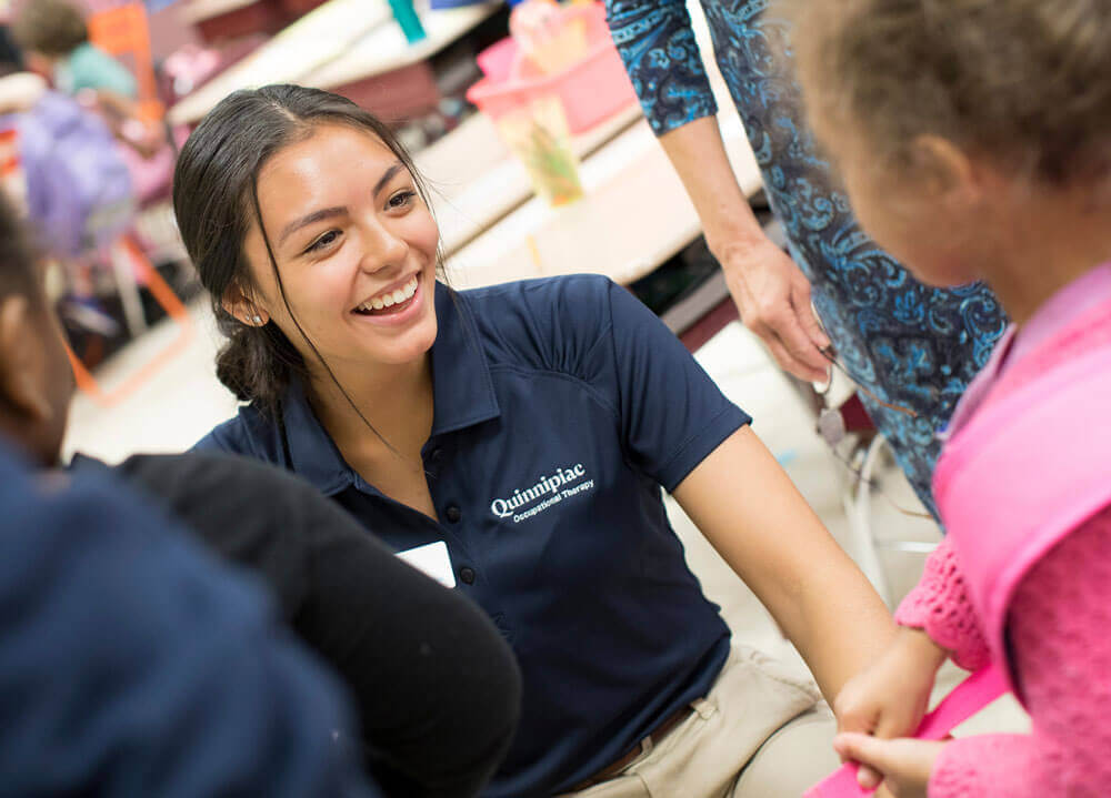 A student teaching first graders about backpack fitting and safety to avoid injury and prevent physical complications