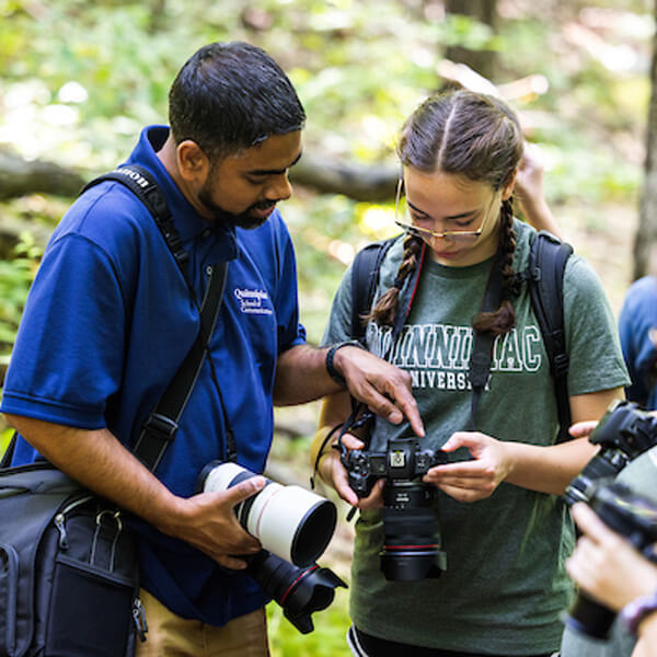 Professor Wasim Ahmad and high school student Norah Araujo looking at a camera