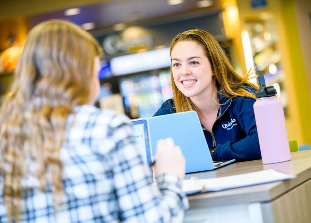 Two graduate students study together with laptops