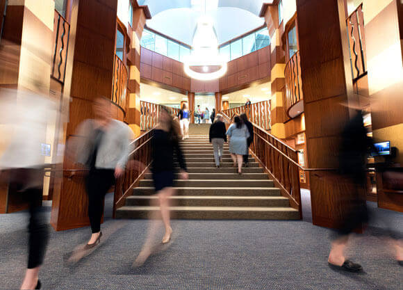 Students and faculty walk through the atrium of the Quinnipiac law library