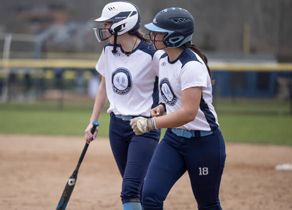 Two girls walking on the softball field