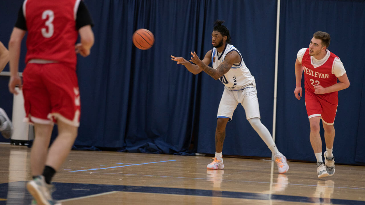 Teammate passing basketball