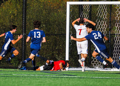 Men running down to the soccer goal