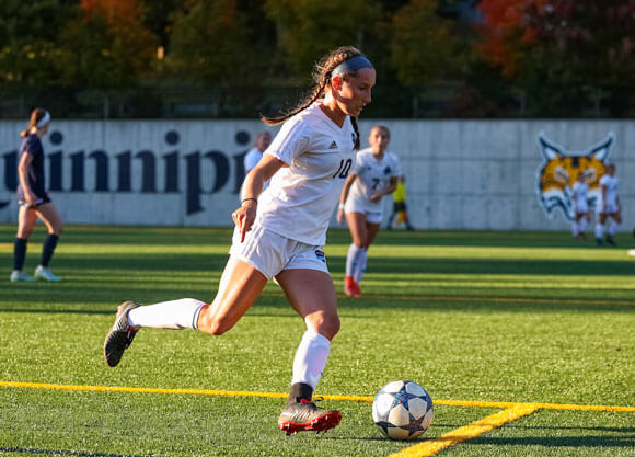 Woman kicking soccer ball