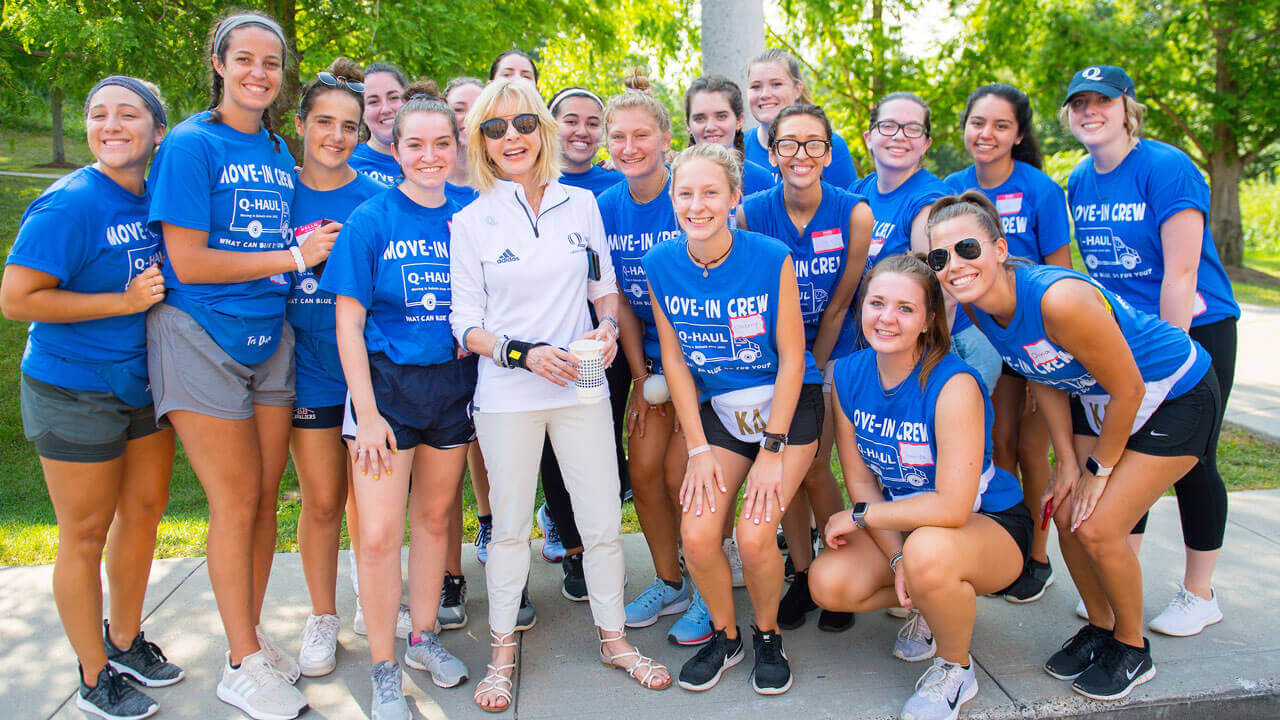 President Olian and a group of students smile for a group photo during move-in day