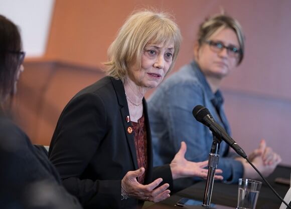 Soto sits behind a microphone at a table during a panel discussion.