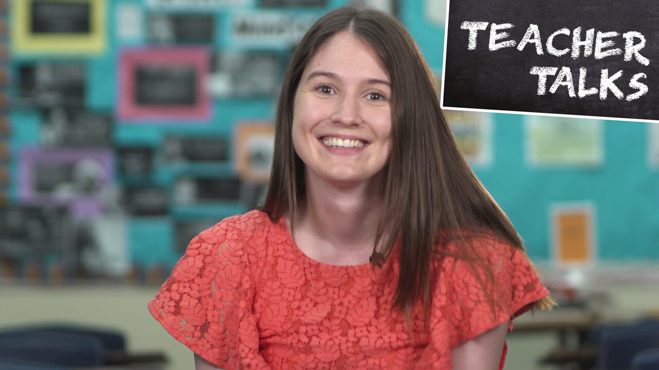 A School of Education alumna smiles at the camera, start of video